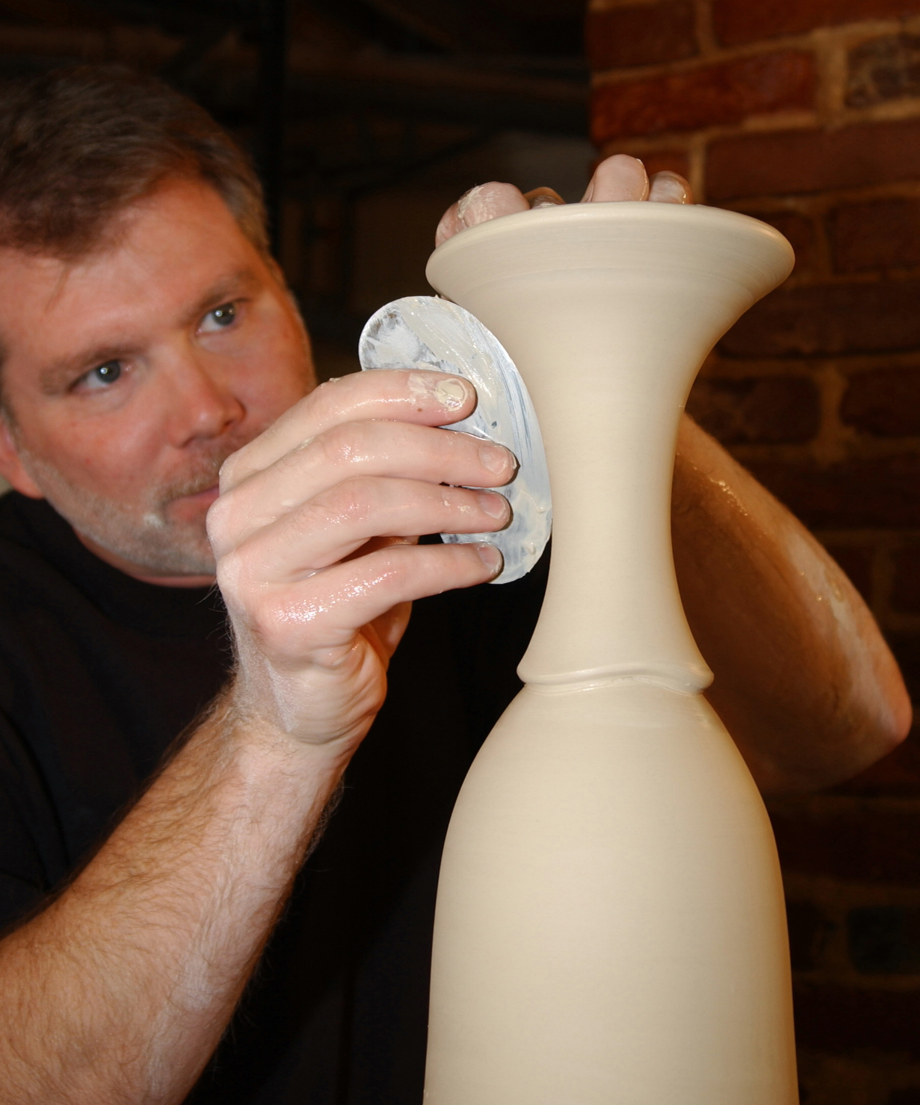 conner working on details of a tall vase