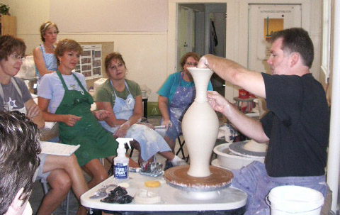 conner burns working on the final detail of a vase at a workshop